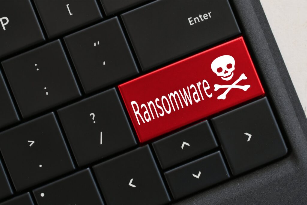 Ransomware concept Computer Keyboard with red RANSOMWARE skull crossbones Hacked virus cyber attack